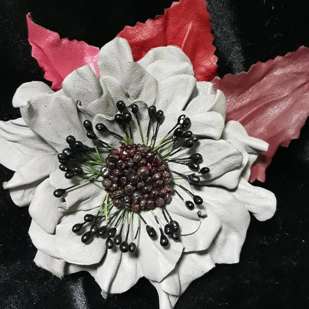 White leather brooch with dark natural stones